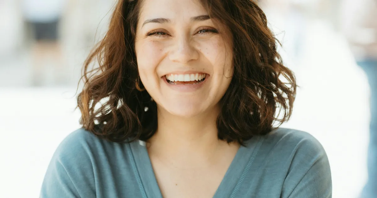 Patient smiling with straighter teeth after completing Invisalign clear aligner treatment